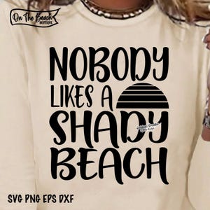 May include: A white t-shirt with black text that reads "Nobody likes a shady beach" with a stylized sunset graphic. The text "On The Beach Boutique" is in the top left corner and "SVG PNG EPS DXF" is at the bottom.