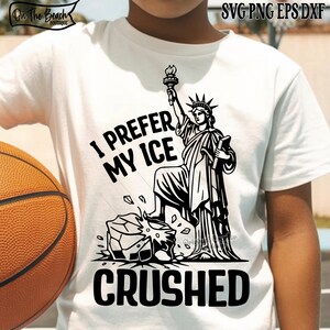 May include: White t-shirt with a black graphic of the Statue of Liberty holding a torch, with the text "I PREFER MY ICE CRUSHED". The shirt also has the logo "On The Beach Boutique" in the upper left corner.