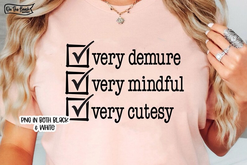 Pode incluir: Uma camiseta rosa com uma lista de verifica&ccedil;&atilde;o que diz "muito recatada", "muito atenta" e "muito fofa".