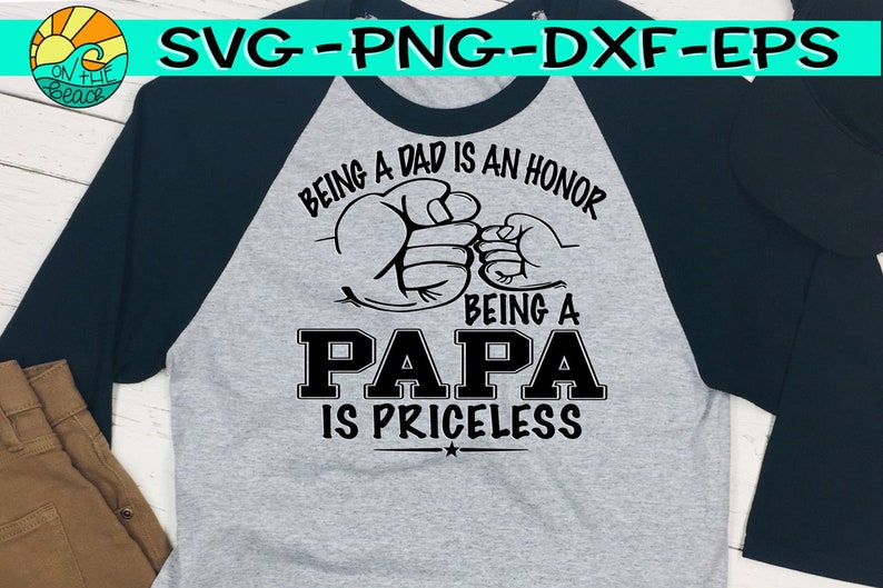 Puede incluir: Una camiseta de b&eacute;isbol gris y negra con el texto "Ser padre es un honor, Ser pap&aacute; no tiene precio" y dos pu&ntilde;os chocando.
