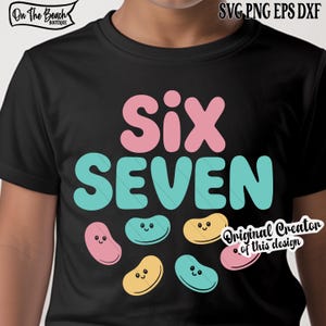 May include: Black t-shirt with the words "Six" in pink and "Seven" in teal. Below the words are six cartoon jelly beans in pink, yellow, and teal. The shirt has the text "On The Beach Boutique" and "Original Creator of this design".