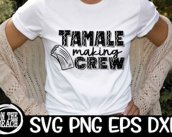 以下が含まれることがあります： 「TAMALE making CREW」の黒い文字とタマレのグラフィックがプリントされた白いTシャツ。ベージュのカーディガンを着た人が着用しています。画像の下部には「ON THE BEACH」と「SVG PNG EPS DXF」の文字があります。