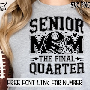 May include: A light gray t-shirt with a black graphic that reads "SENIOR MOM" with a football helmet and the text "THE FINAL QUARTER." The shirt also has the text "FREE FONT LINK FOR NUMBER" at the bottom. A football is held in the image.