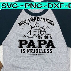 Puede incluir: Una camiseta de b&eacute;isbol gris y negra con el texto "Ser padre es un honor, Ser pap&aacute; no tiene precio" y dos pu&ntilde;os chocando.