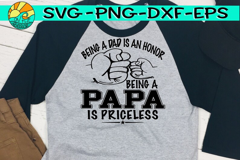 Puede incluir: Una camiseta de b&eacute;isbol gris y negra con el texto "Ser padre es un honor, Ser pap&aacute; no tiene precio" y dos pu&ntilde;os chocando.