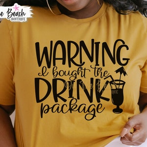 May include: A mustard yellow t-shirt with the text "WARNING I bought the DRINK package" in black lettering. A black silhouette of a cocktail glass with a straw and umbrella is next to the text.