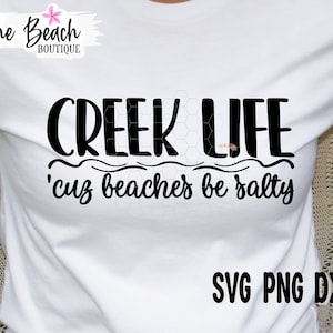 May include: White t-shirt with black text that reads "CREEK LIFE 'cuz beaches be salty". The text is in a handwritten font. Below the text is "SVG PNG DXF EPS".