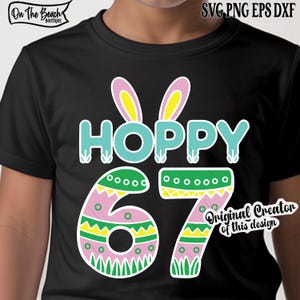 May include: Black t-shirt with a colorful Easter-themed graphic. The design features the word "HOPPY" in turquoise with bunny ears above, and the numbers "67" decorated with Easter egg patterns. The shirt includes the text "Original Creator of this design".