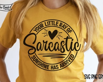 Könnte beinhalten: Ein gelbes T-Shirt mit einem schwarzen Kreis-Motiv, auf dem "Your Little Ray of Sarcastic Sunshine Has Arrived" steht.