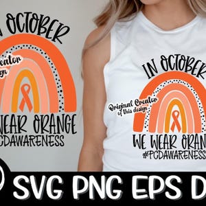 May include: A digital design featuring a rainbow with an orange ribbon in the center. The text "In October We Wear Orange #PCDAwareness" is displayed below the rainbow. The design is suitable for use on t-shirts, mugs, and other merchandise.