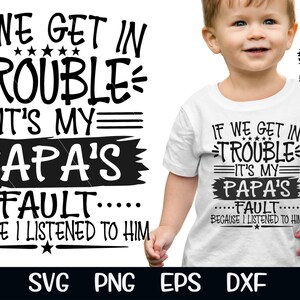 May include: White toddler t-shirt with the text "IF WE GET IN TROUBLE IT'S MY PAPA'S FAULT BECAUSE I LISTENED TO HIM" in black. The shirt is worn by a young child.