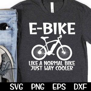 May include: A dark grey t-shirt with white text that reads "E-BIKE LIKE A NORMAL BIKE JUST WAY COOLER". A white silhouette of an e-bike is above the text.