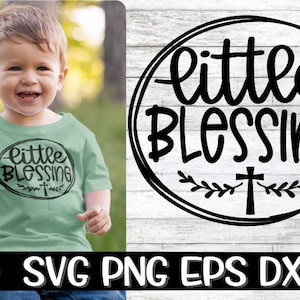 May include: A young child wearing a light green t-shirt with the words "Little Blessing" in a black oval design. The design includes a cross and leaves. The image also shows a graphic with the same design.