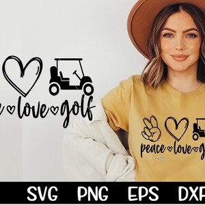 May include: Peace, love, and golf design featuring a peace sign, heart, and golf cart. The design is in black and white and is shown on a yellow t-shirt.
