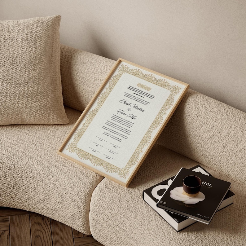 May include: A rectangular framed document featuring a gold-colored ornate border and black printed text. The document displays the names Noah Abraham and Elyn Nui in a script font, followed by lines for signatures and dates on a white background.
