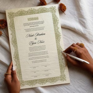 May include: A cream-colored wedding contract featuring an intricate olive green floral border. The document displays the names Noah Ibrahim and Elyza Noor in elegant script, accompanied by printed text and signature lines for the groom, bride, and witnesses.