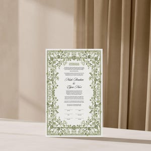 May include: A white wedding ketubah with a green floral border. The text reads "Noah Brashkin & Gwen Rivers".