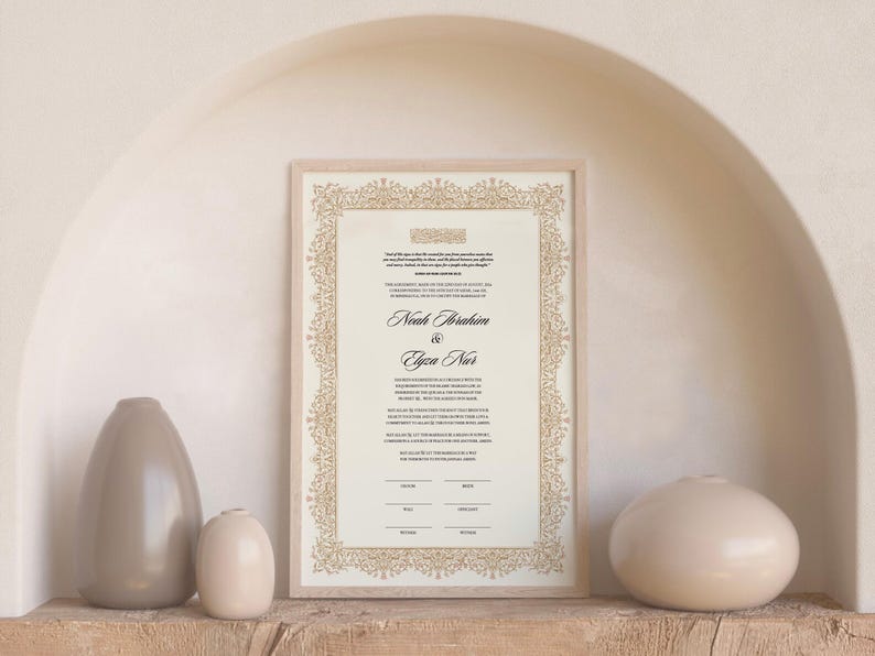 May include: A rectangular framed wedding certificate featuring a cream-colored background with black printed text and a decorative gold-toned filigree border. The names Noah Ibrahim and Elyza Nur are printed in a prominent script font in the center.
