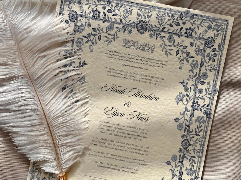 May include: A cream-colored wedding certificate with blue floral borders. The text reads "This agreement, made on the 27th day of August, 2019, corresponding to the 15th day of Safar, 1441 AH, in Mississauga, ON, is to formally the marriage of Noah Ibrahim & Elyza Noor."