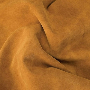 May include: A close-up of a piece of brown suede fabric with a soft, textured surface.