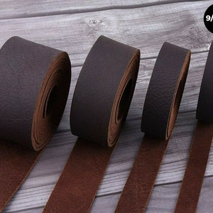 May include: Four rolls of brown leather cord, varying in width, laid out on a wooden surface. The text "9/10 oz." is visible in the upper right corner of the image.