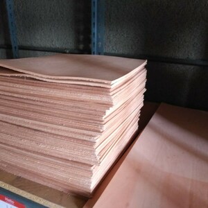 May include: A stack of light brown leather sheets, likely for crafting or upholstery.