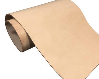 May include: A roll of natural, undyed vegetable-tanned leather with a smooth, matte surface. The material is light beige in color and features a consistent, firm texture throughout the length of the hide, showing a clean edge and grain.
