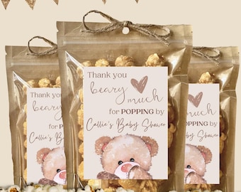 May include: Three clear plastic pouches filled with popcorn, each tied with twine at the top. A white label on each pouch features a brown teddy bear illustration and the text: Thank you beary much for POPPING by Callie's Baby Shower.