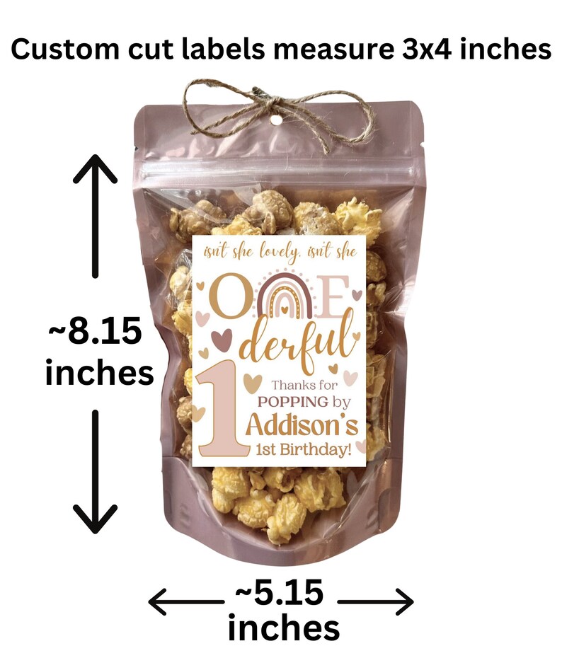 May include: A clear plastic bag filled with popcorn and a pink and brown label that says "One-derful" with a rainbow and hearts. The label also says "Thanks for popping by Addison's 1st Birthday!" The bag is 8.15 inches tall and 5.15 inches wide.