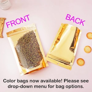 Puede incluir: Dos bolsas doradas y brillantes, resellables, una llena de jud&iacute;as verdes peque&ntilde;as y la otra vac&iacute;a. La palabra "FRONT" est&aacute; encima de la bolsa llena y "BACK" encima de la bolsa vac&iacute;a. El texto "Color bags now available! Please see drop-down menu for bag options." est&aacute; abajo.