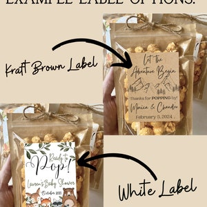 May include: Two examples of favor bags with labels for a baby shower. The first bag has a kraft brown label with the text "Let The Adventure Begin" and "Thanks for POPPING by! Monica & Chandler February 5, 2024." The second bag has a white label with the text "Ready to Pop! Lauren's Baby Shower October 2023" and a woodland animal illustration.