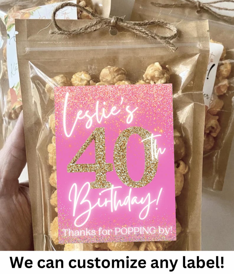 Pu&ograve; includere: Un sacchetto per bomboniere di compleanno rosa e oro pieno di popcorn al caramello. Il sacchetto ha un'etichetta che dice "Leslie's 40th Birthday! Thanks for POPPING by!"