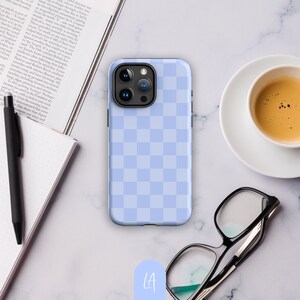 May include: A light blue phone case with a checkered pattern. The case has a black camera bump with three lenses.