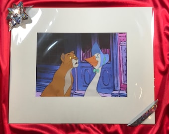 Könnte beinhalten: Eine gerahmte Illustration einer braunen Katze und einer weißen Gans mit einem blauen Häubchen. Die Katze schaut die Gans mit einem überraschten Ausdruck an. Die Gans schaut die Katze mit einem neugierigen Ausdruck an.
