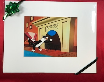 Può includere: Un gatto di cartone animato bianco e nero con un palloncino blu davanti a un camino. Il gatto sta guardando il palloncino e ha un'espressione sorpresa sul viso.