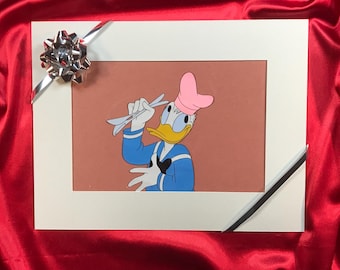 Può includere: Un'illustrazione di cartone animato incorniciata di un'anatra che indossa un cappello da cuoco rosa e una camicia da marinaio blu, tenendo un paio di utensili bianchi.