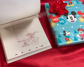 Könnte beinhalten: Ein Daumenkino mit einer Strichzeichnung von Donald Duck, der auf eine leere Staffelei zeigt, neben einem Geschenk, das in hellblaues Papier mit einem Mickey- und Minnie-Maus-Muster und einer roten Schleife eingewickelt ist.