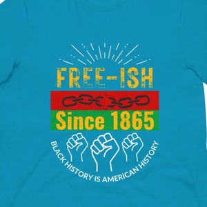 Peut inclure: Un t-shirt turquoise avec un motif graphique. Le motif comprend les mots "FREE-ISH Since 1865" en jaune et vert, une chaîne et des poings levés. Le texte "BLACK HISTORY IS AMERICAN HISTORY" est disposé en cercle.