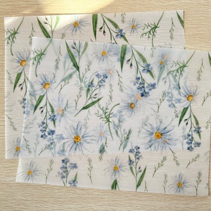 May include: Two sheets of white fabric with a blue and green floral pattern. The fabric features a repeating pattern of blue daisies and green leaves.