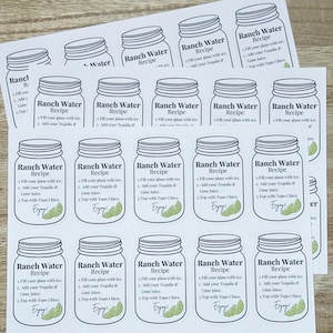 May include: A set of 16 white labels with black outlines of mason jars. Each label has the text "Ranch Water Recipe" and instructions for making the drink. The instructions include filling a glass with ice, adding tequila and lime juice, and topping with Topo Chico.