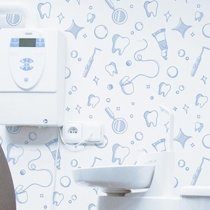 Peut inclure: Intérieur d'un cabinet dentaire avec un fauteuil dentaire marron et blanc, une lampe d'examen blanche et un mur décoré d'un motif bleu clair de dents et d'instruments dentaires. L'environnement est propre et moderne.