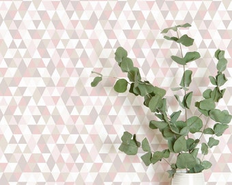 May include: A white ceramic vase with a sprig of green eucalyptus leaves against a background of pink and grey geometric wallpaper.