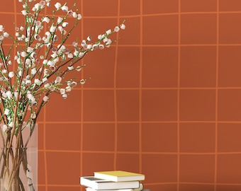 May include: A vase with white flowers sits on a wooden surface in front of a wall with a burnt orange grid pattern. Two white pineapple-shaped decorative objects are on the right side of the image.