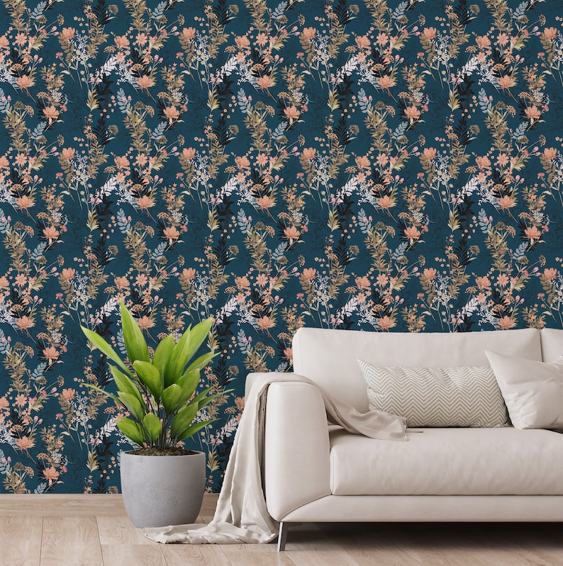 Teal Wildflowers self-adhesive wallpaper with scattered leafy stems and peach blooms on deep teal, living room wall behind sofa.