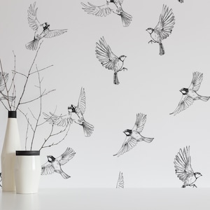 Puede incluir: Papel tapiz blanco con un patrón repetitivo en blanco y negro de pájaros en vuelo. Dos jarrones de cerámica blanca con borde negro están en primer plano.