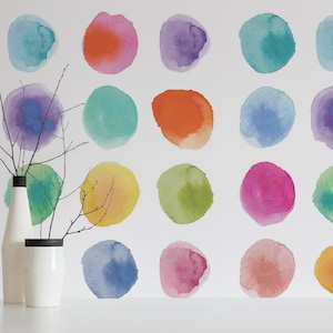 Könnte beinhalten: Eine weiße Wand mit einem sich wiederholenden Muster aus bunten Aquarellkreisen. Die Kreise sind in Blautönen, Grüntönen, Violett, Orange, Gelb und Rosa.