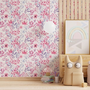 Pink Watercolor Botanical peel and stick wallpaper shows a soft floral wall in a nursery, with a wooden dresser.