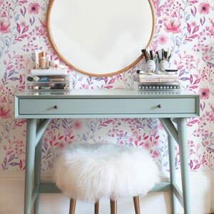 Pink Watercolor Botanical removable wallpaper with soft floral stems behind a round wooden mirror and small vanity.