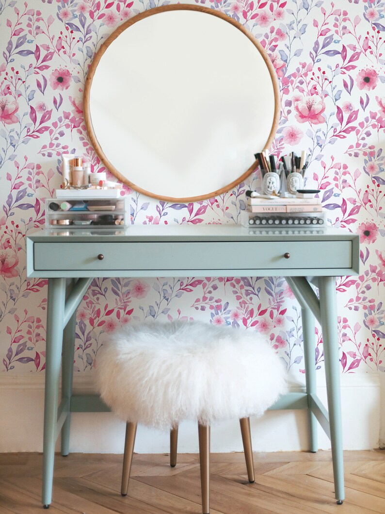 Pink Watercolor Botanical removable wallpaper with soft floral stems behind a round wooden mirror and small vanity.