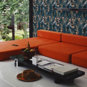 Teal Wildflowers peel and stick wallpaper covers a wall with scattered slender stems on deep teal, peach and gold accents.